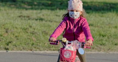 Kind mit Maske auf Velo