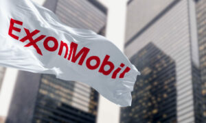 ExxonMobil flag waving in the wind in a financial district