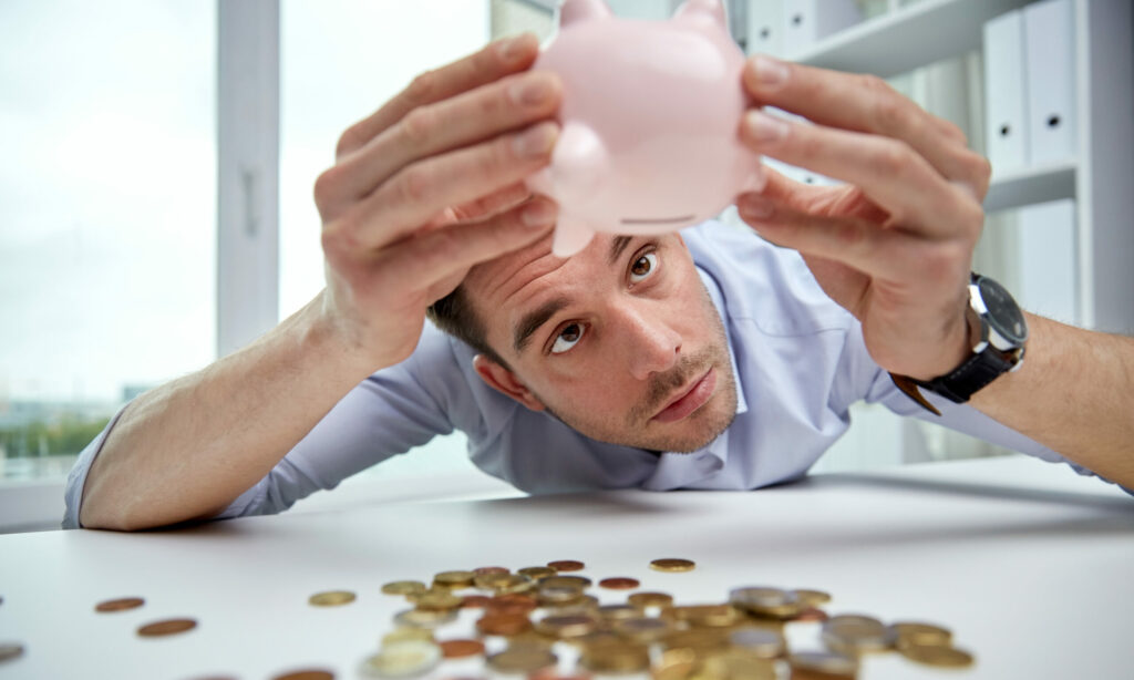 businessman with piggy bank and coins at office