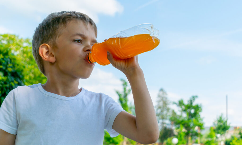 Little boy with a bottle of sweet drink