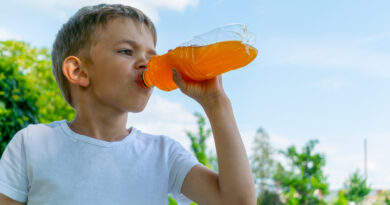 Little boy with a bottle of sweet drink
