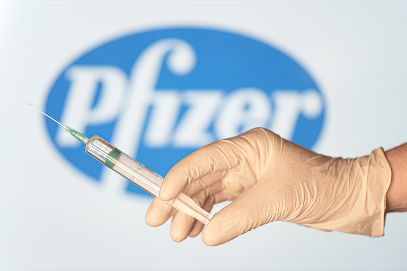 Spritze vor Pfizer Logo