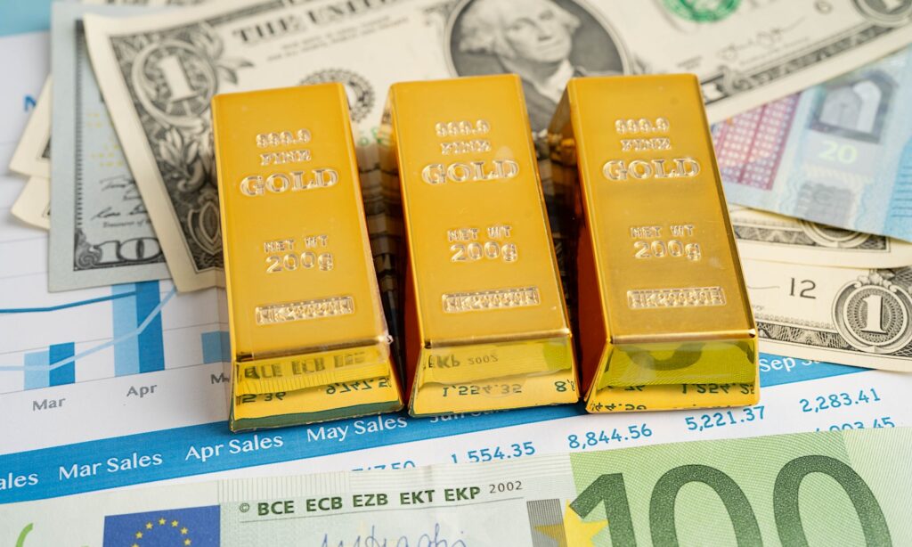 Gold bars with US dollar and Euro banknote money, finance trading investment business currency.