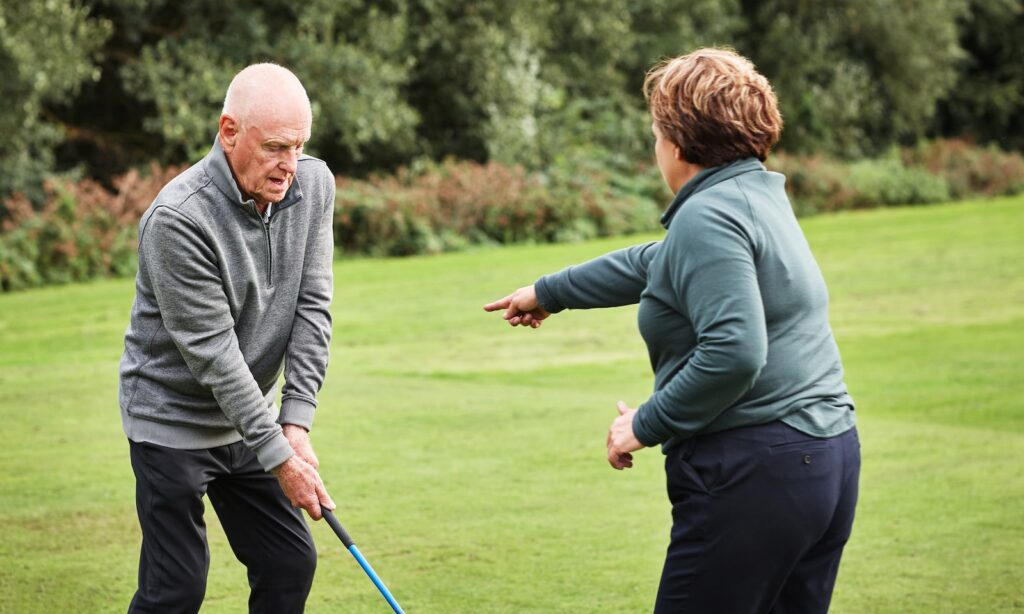 Golf, man and woman on grass for coaching, sports club and support for weekend hobby in retirement. Game, help and old couple on green lawn for competition, outdoor fun and golfer learning to swing.